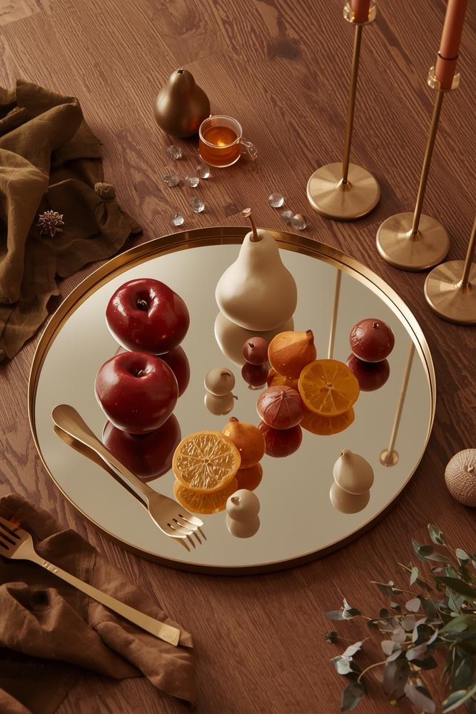 Spiegeltablett mit skulpturalen Früchten und Messingbesteck